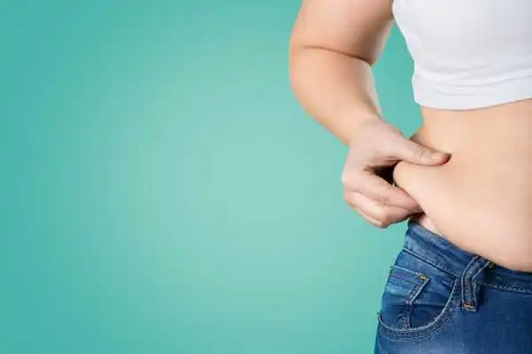 Image of woman pinching her love handles to show weight gain Earley